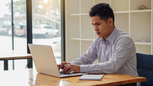 Man looking at camera while sitting on table