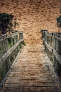 Footbridge by railing against sky