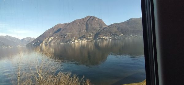 Scenic view of lake and mountains against clear sky