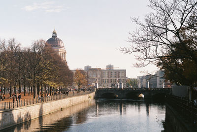 Bridge over river against buildings in city