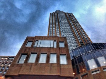 Low angle view of modern building against cloudy sky