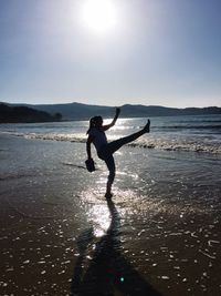 Full length of silhouette woman at beach against sky during sunset