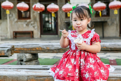 Portrait of cute girl holding ice cream outdoors