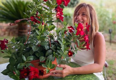 Woman with red flowers on plant