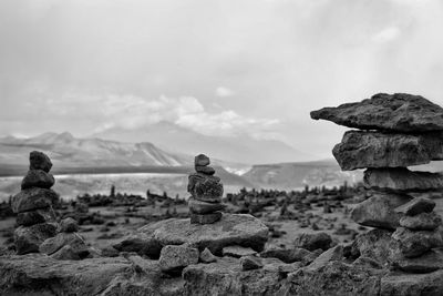 Stack of rocks on mountain against sky