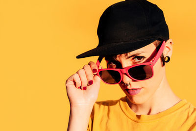 Portrait of man wearing sunglasses against gray background