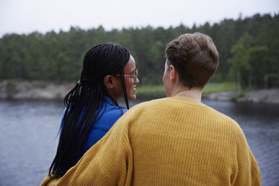 Female couple relaxing by river