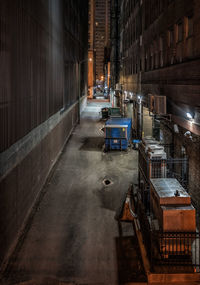 Alley amidst buildings in city at night