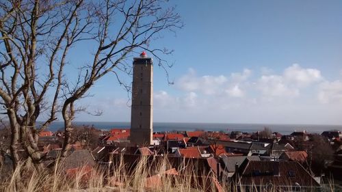 Built structure by sea against blue sky