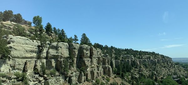 Panoramic view of rocks and trees against clear sky