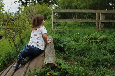 Girl sitting on wood in park