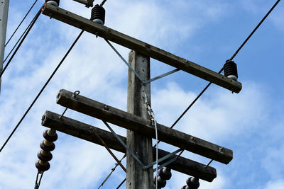 Low angle view of telephone pole against sky