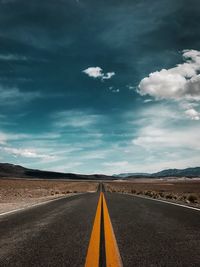 Empty road against cloudy sky