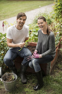 Portrait of happy friends gardening together outdoors