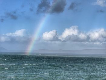 Scenic view of rainbow over sea against sky