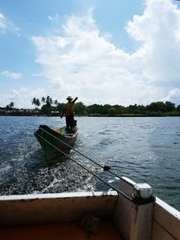 Man in boat on water against sky