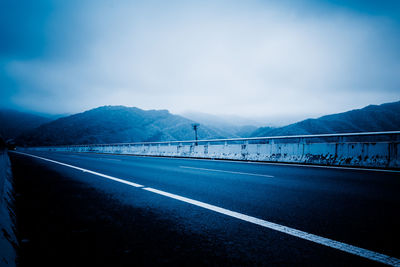 View of road by mountain against sky