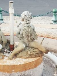 Close-up of angel statue against water