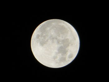Low angle view of full moon against clear sky at night
