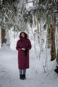 Beautiful woman in a warm coat in winter in a forest covered with snow person