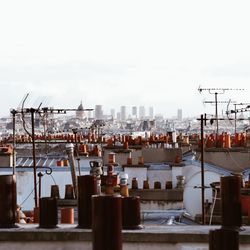 Cityscape by harbor against sky