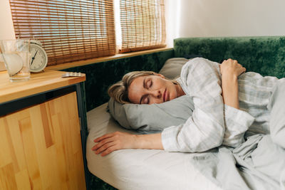 Portrait of young woman sleeping on bed at home