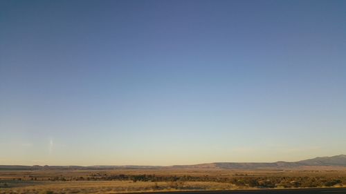 Scenic view of field against clear blue sky