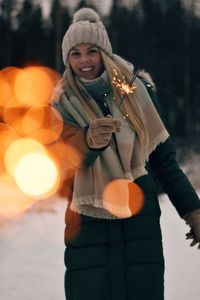 Portrait of young woman holding sparkler