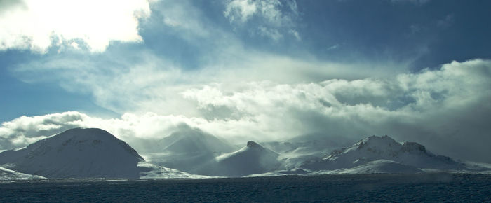 Scenic view of mountains against cloudy sky