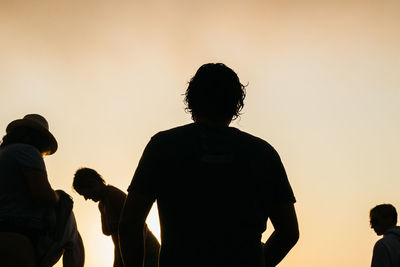 Rear view of silhouette people against sky during sunset