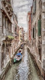 Canal amidst buildings against sky