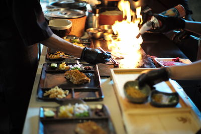 Midsection of man preparing food on barbecue grill