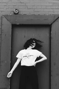 Portrait of woman standing against wall