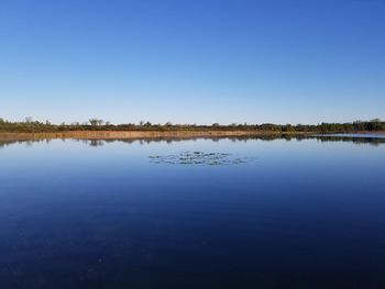 Scenic view of lake against clear blue sky