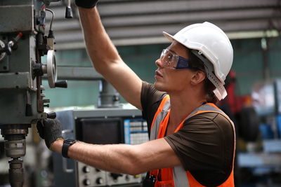 Side view of young man working in factory