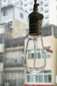 Close-up of light bulb against building