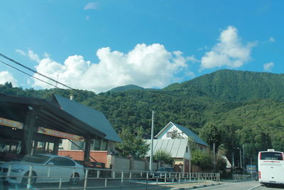 Residential district by mountain against sky