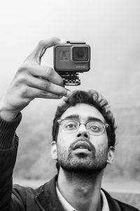 Close-up of man looking at camera against sky