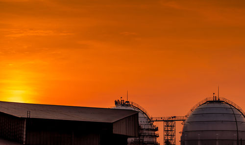 Industrial gas storage tank. lng or liquefied natural gas storage tank. red and orange sunset sky. 