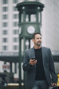 Young man using mobile phone in city