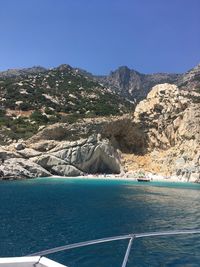 Scenic view of sea and mountains against clear blue sky