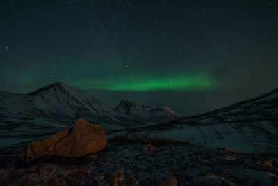 Scenic view of snowcapped mountains against sky at night