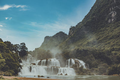 Scenic view of waterfall against sky