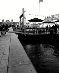 Bridge over river in city against clear sky