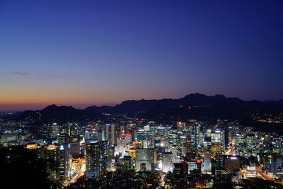 High angle view of illuminated city against sky at night