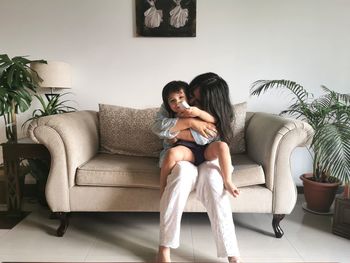 Woman sitting on sofa at home