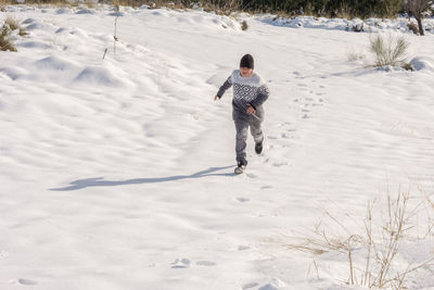 Young man having fun running in big snow,