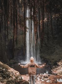 Full length of man standing by trees in forest