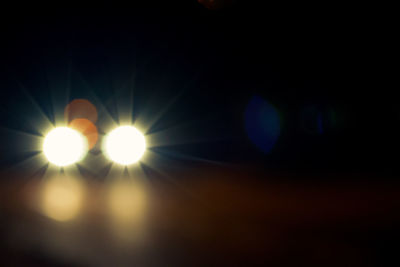 Illuminated lights against sky during sunset