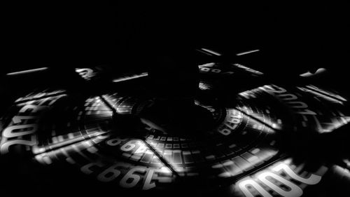 Close-up of illuminated lighting equipment against black background